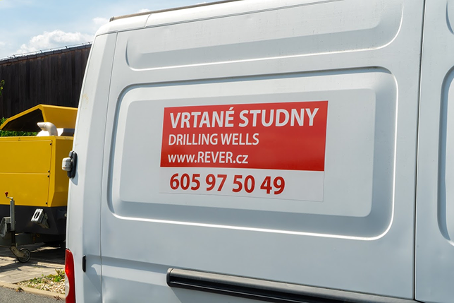 Bílá dodávka s polepem společnosti REVER.CZ